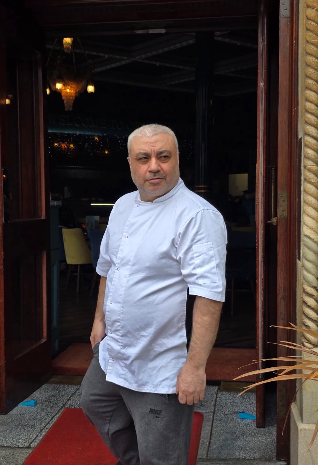 Chef Haydar Sevincli in chef whites at a restaurant entrance